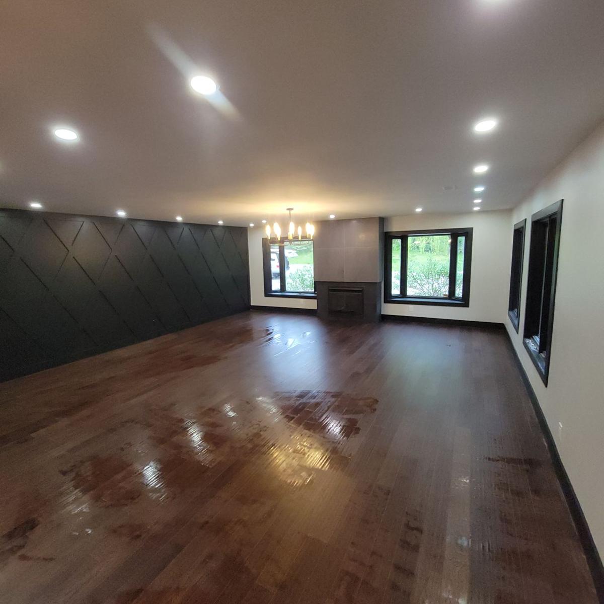 Finished family room with new hardwood floors, feature wall and pot lights